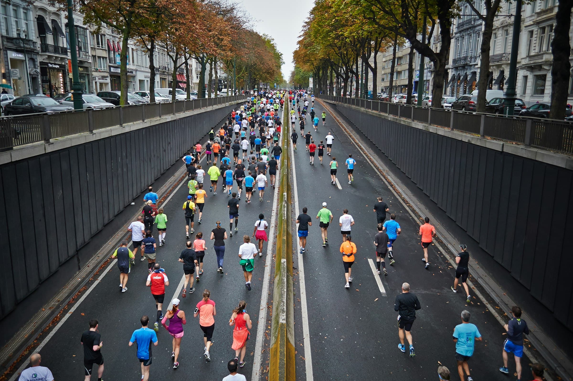 Hundreds of runners filling a city road during a mass-participation run